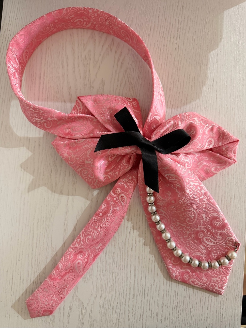Pearl-Trim Pink Paisley Bow Necklace with Black Ribbon Accent
Handmade.